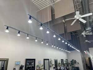 Rows of track lights beneath an exposed ceiling in a retail interior